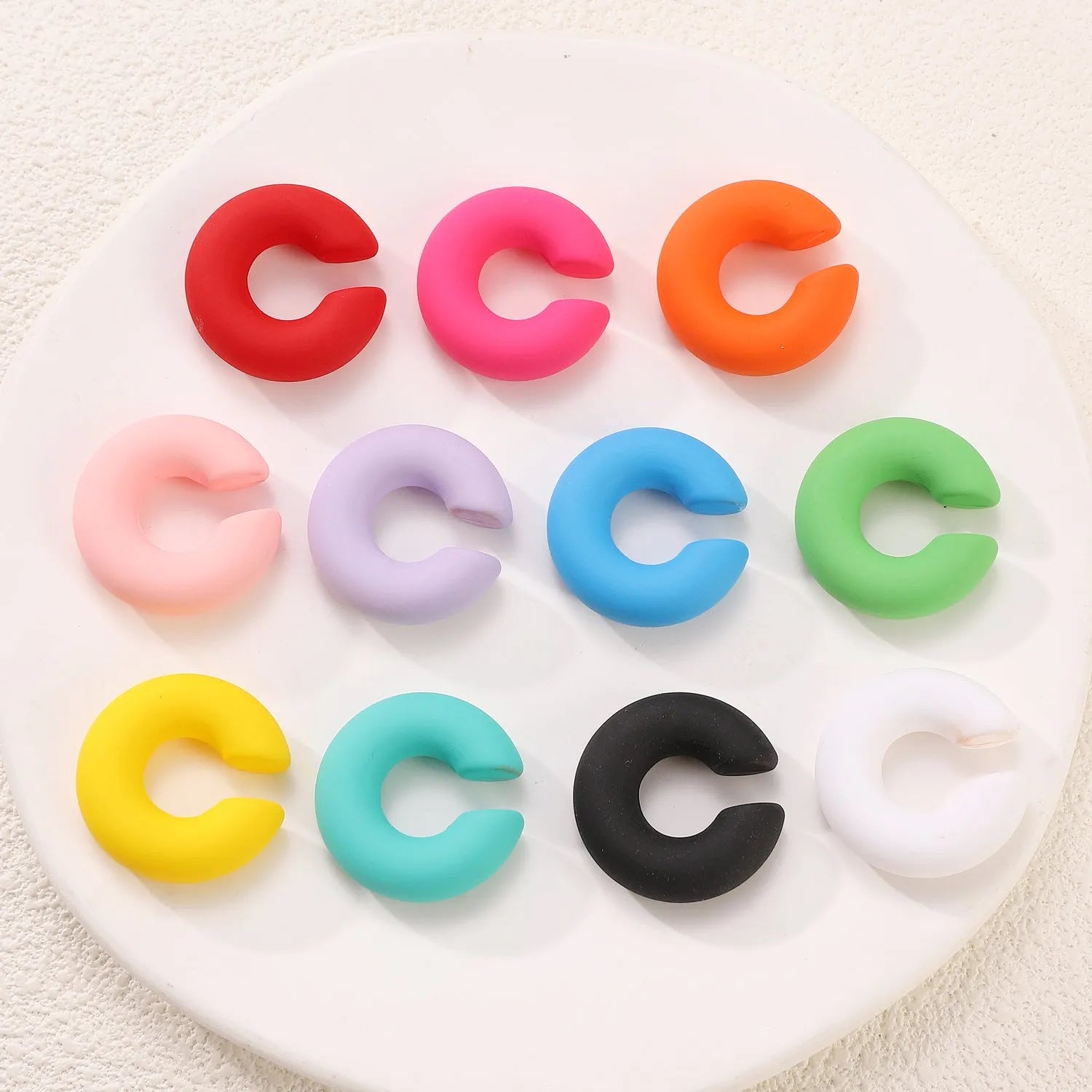 Round C-shaped geometric clip-on earrings with matte finish in various candy colours
