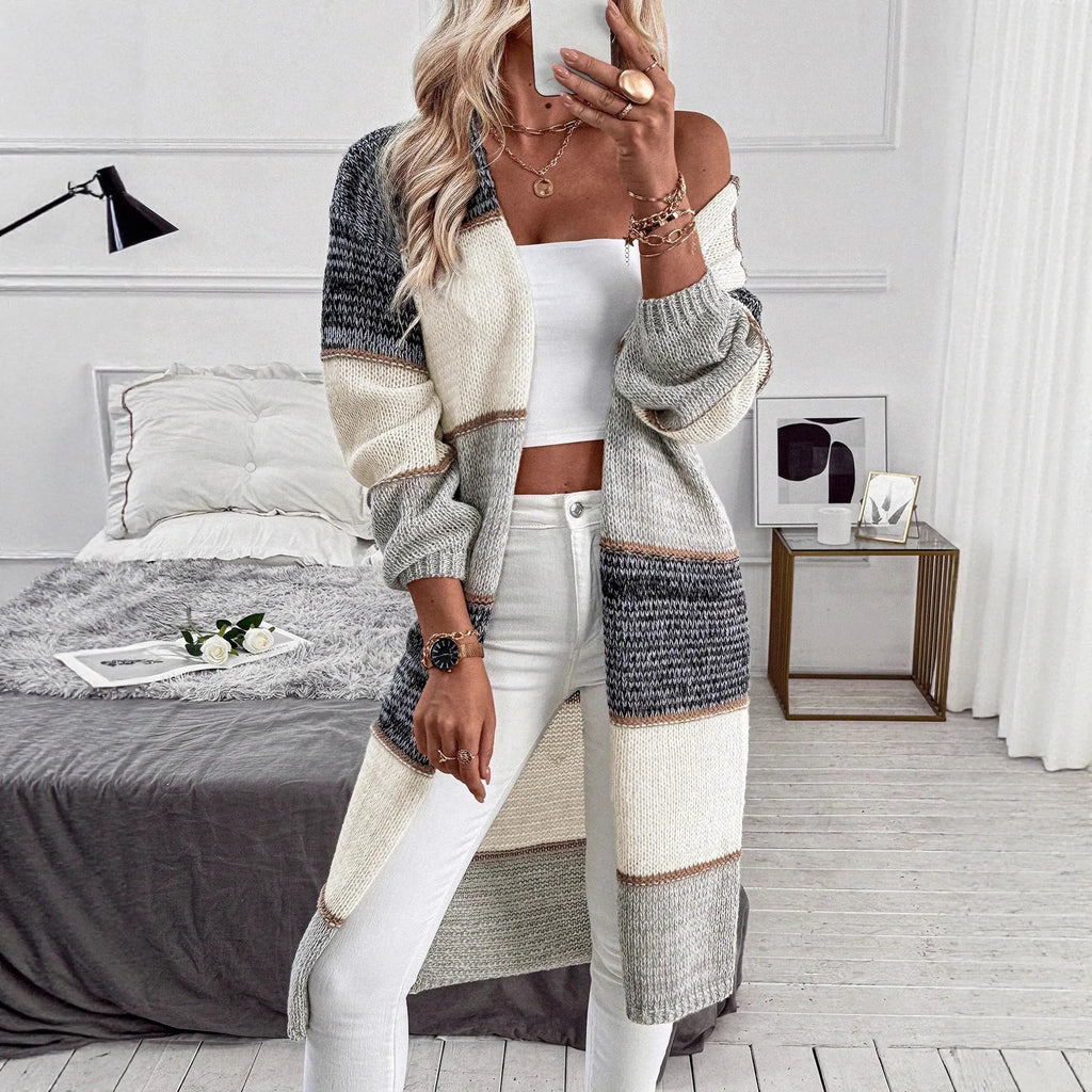 Grey women's long knitted cardigan with loose fit and long sleeves, shown in stripe or plaid pattern.
