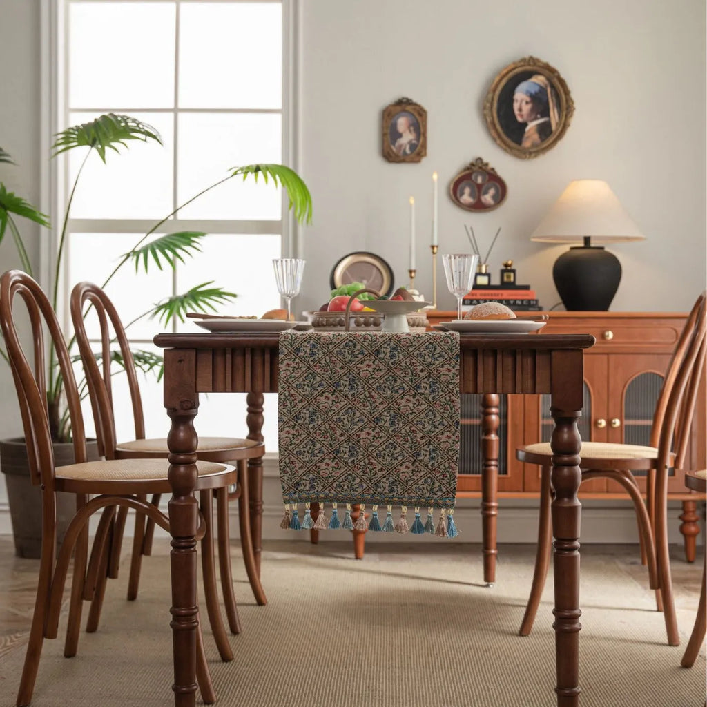 Dark blue striped jacquard table runner with tassel trim laid on a wooden table