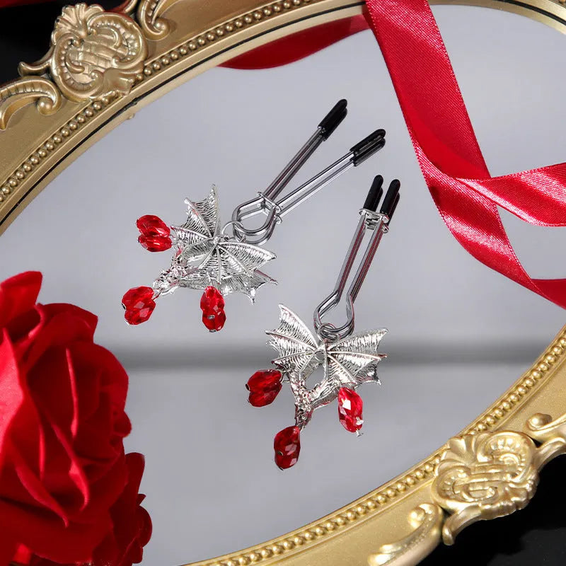 Silver diamond bat design nipple clamp with ruby accents and adjustable tension mechanism