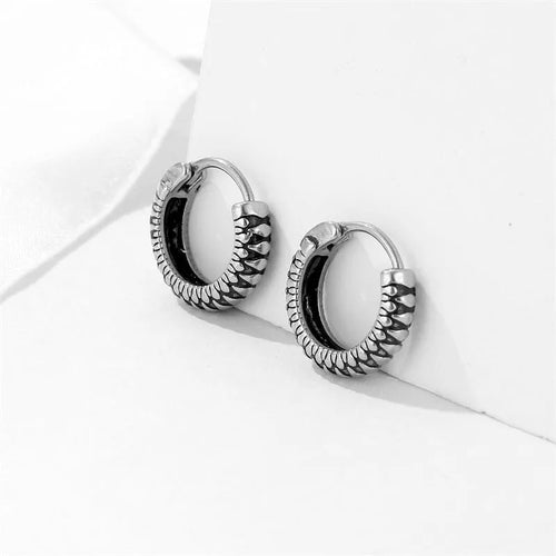 Silver geometric twist earrings with circular elements on white background