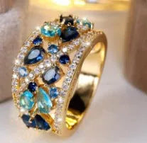 Women's round hollow copper fashion ring with a choice of gemstone colours, shown in gold and platinum finishes.
