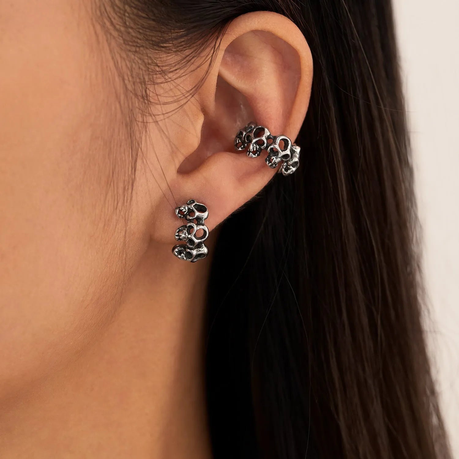 Stainless steel skull earrings with hollow geometric design and ear clip closure