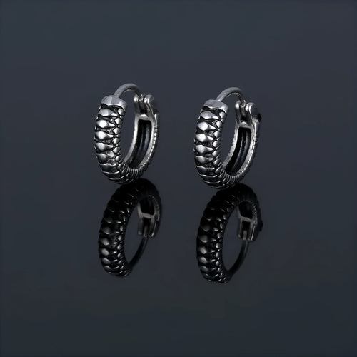 Silver geometric twist earrings with circular elements on white background