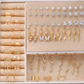 108 gold and yellow geometric and round alloy drop earrings laid out.