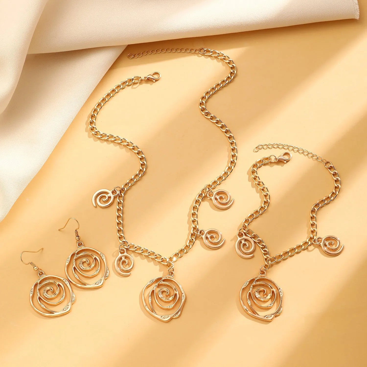 Women's spiral donut jewellery set with necklace, bracelet and earrings in gold or silver geometric design