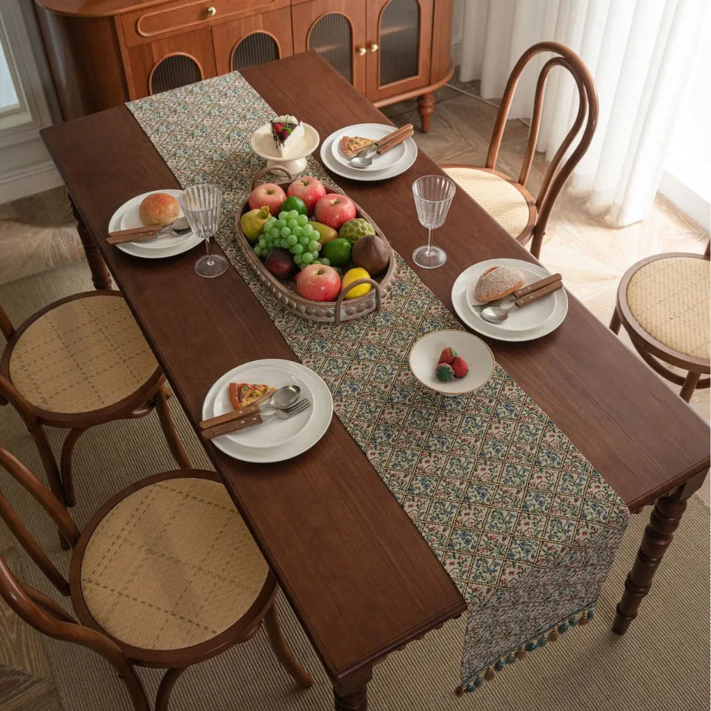 Dark blue striped jacquard table runner with tassel trim laid on a wooden table