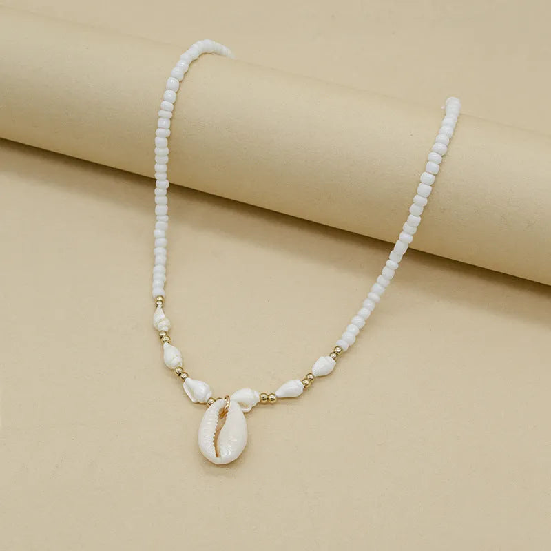 White conch shell bead necklace with a mother-of-pearl pendant on a regular chain.