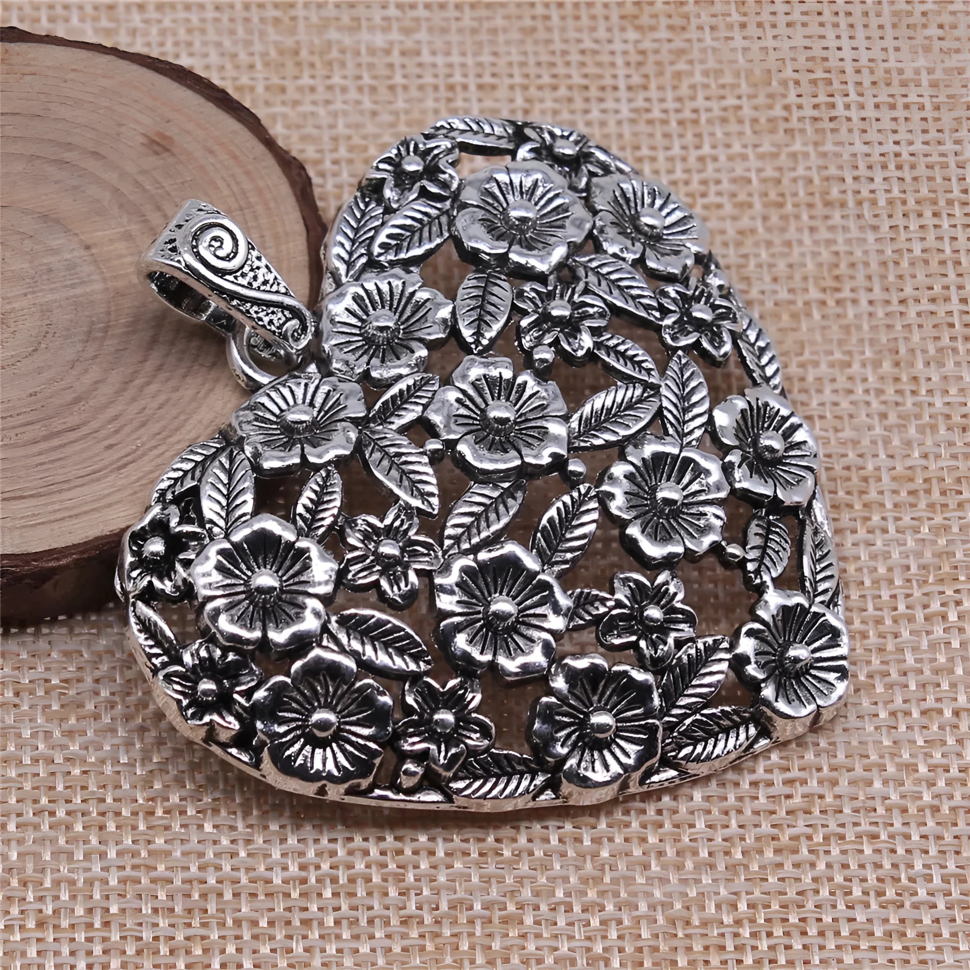 Ancient silver hollow flower love pendant measuring 67mm by 58mm with electroplated finish