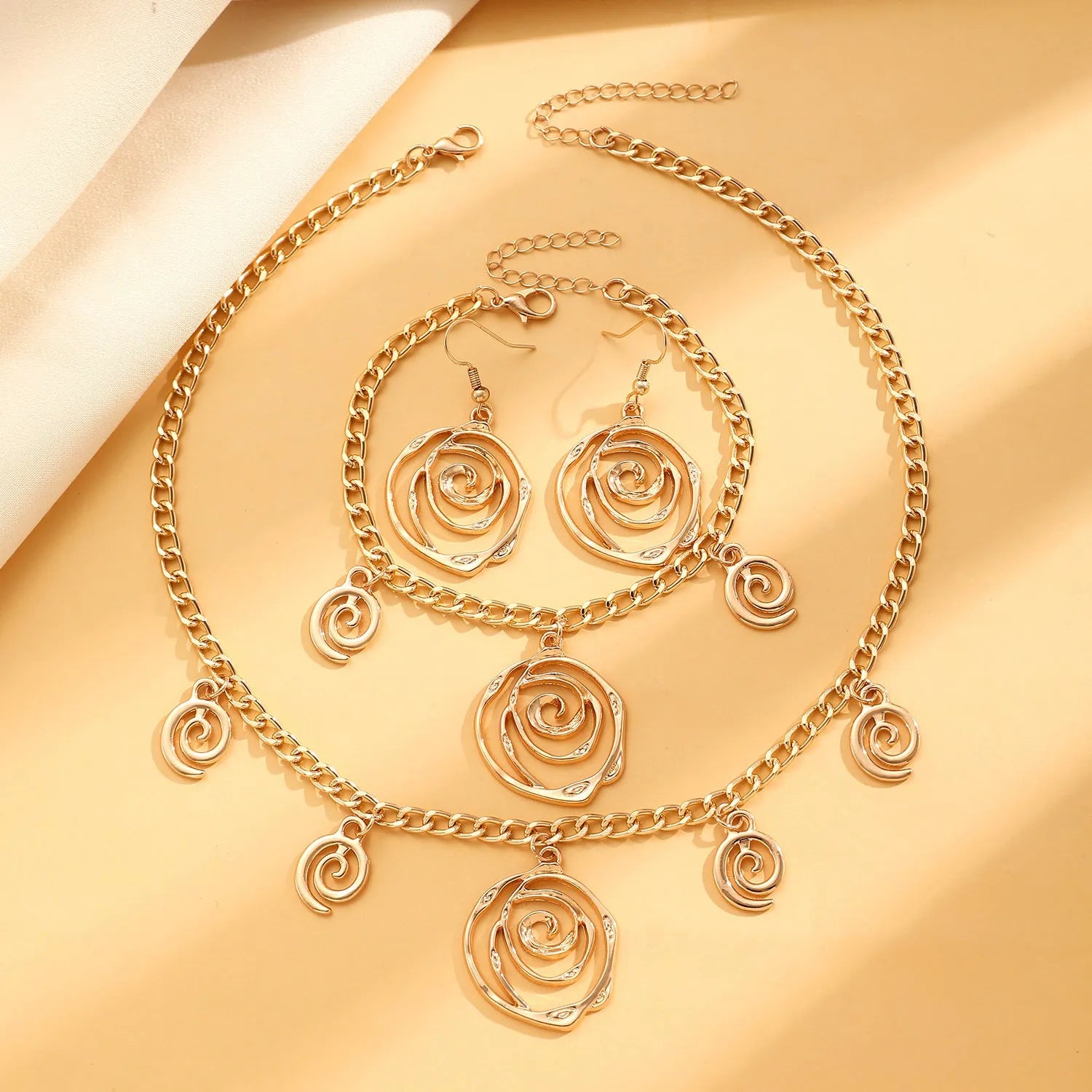 Women's spiral donut jewellery set with necklace, bracelet and earrings in gold or silver geometric design