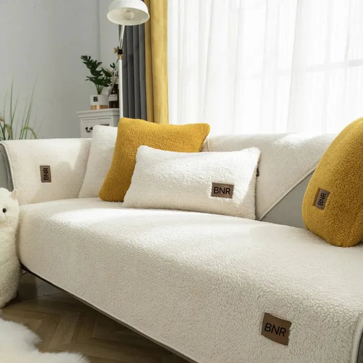 Lambswool sofa cover in blue on a grey sofa, showing simple solid colour and cloth liner style.