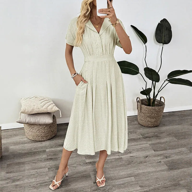 Light green women's lapel collar shirt dress with waist tie and side pockets on a dress form.