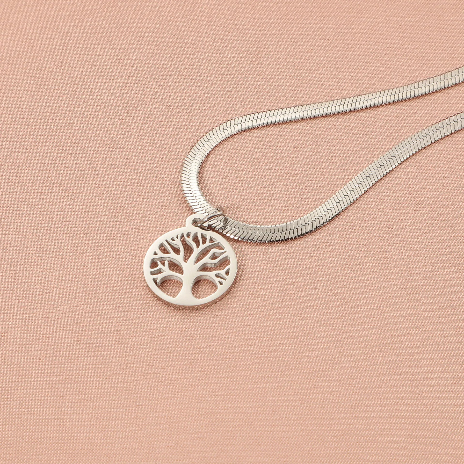 Stainless steel lucky tree pendant necklace on a snake bones chain, shown in gold and steel colour options.