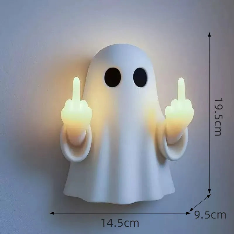 Small white ghost statue night lamp on a shelf for Halloween decor.
