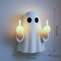 Small white ghost statue night lamp on a shelf for Halloween decor.