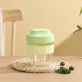 Green plastic salad cup with clear lid and white spoon on a table