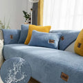 Lambswool sofa cover in blue on a grey sofa, showing simple solid colour and cloth liner style.