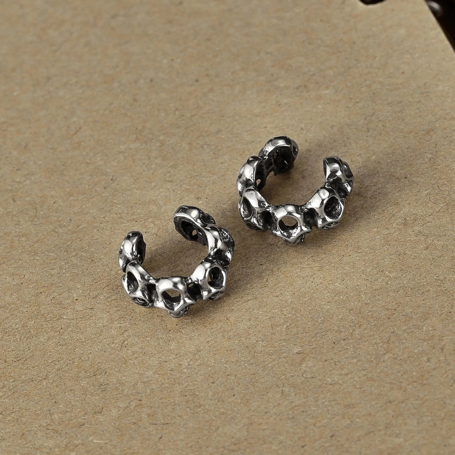 Stainless steel skull earrings with hollow geometric design and ear clip closure