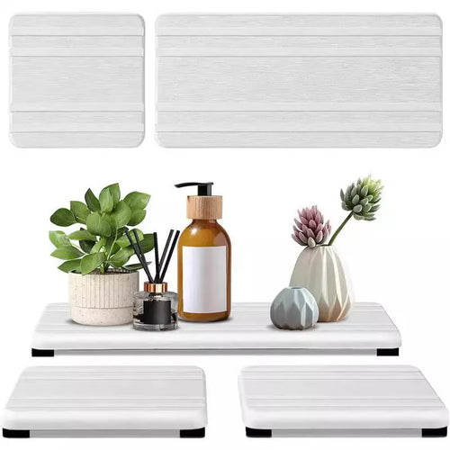 Three square diatom oil water draining pads in solid colours on a bathroom countertop.