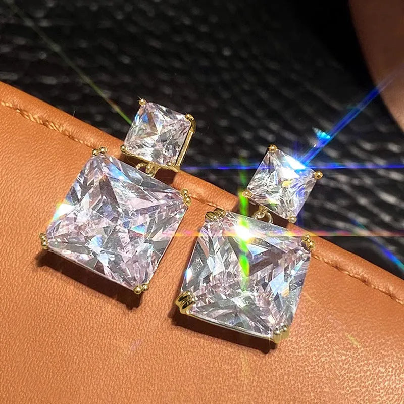 A pair of geometric square design copper earrings for women in gold and white gold colour options.