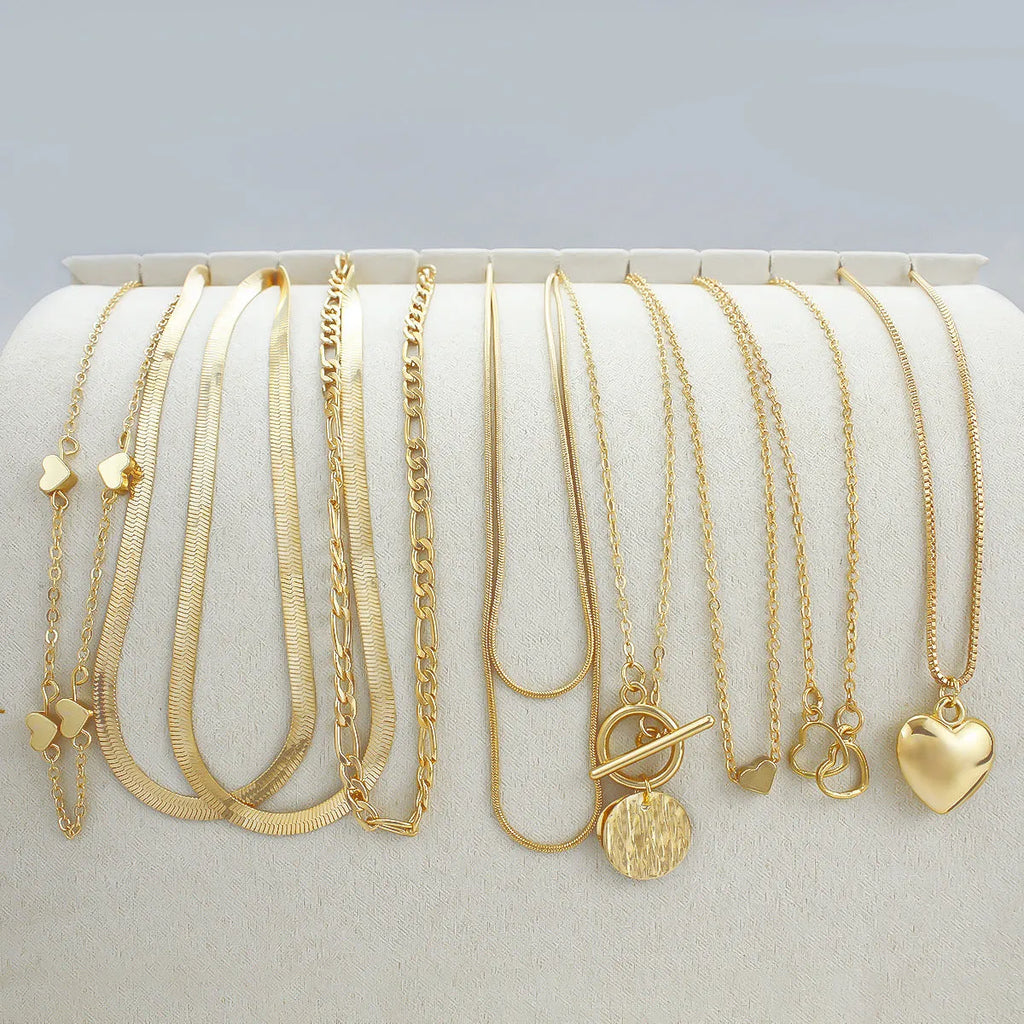 Set of ten gold-coloured women's necklaces with snake bones chains and alloy pendants.