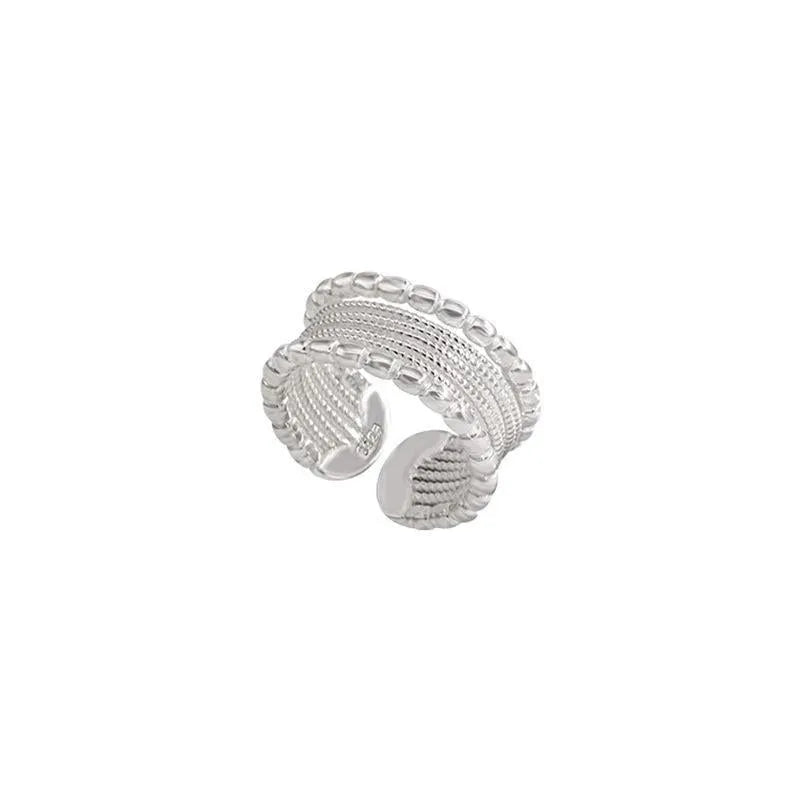 Copper geometric ring with woven twisted multilayer design and adjustable opening.