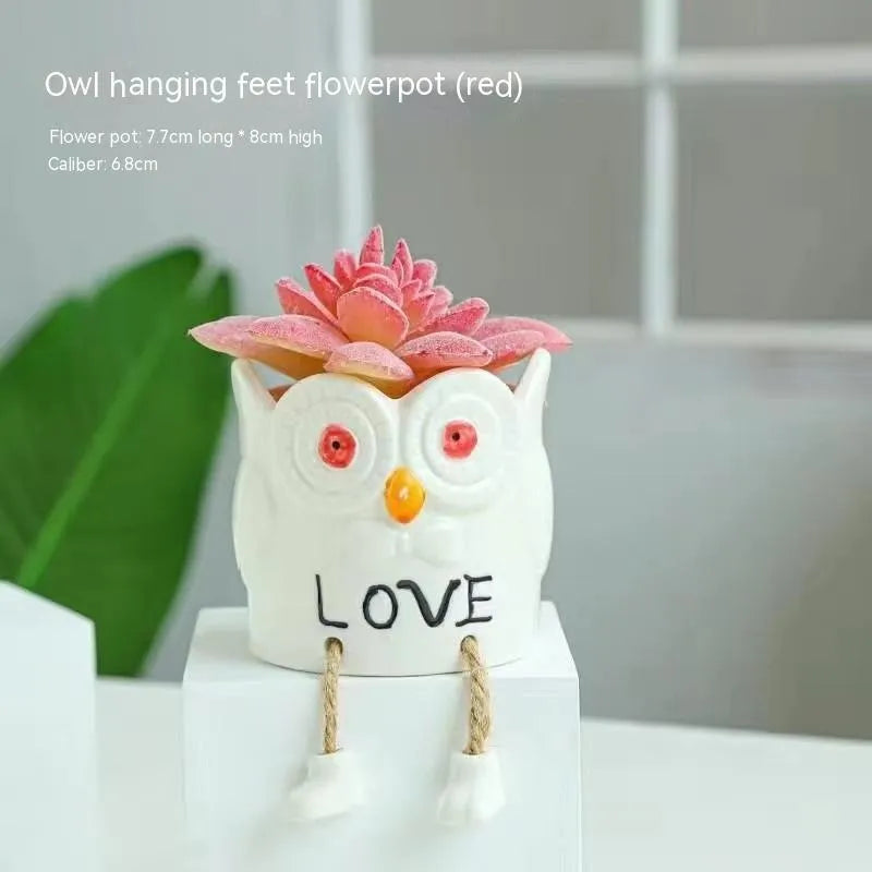 Ceramic hanging foot flowerpot in a cartoon style, shown on a desktop with a small succulent plant.