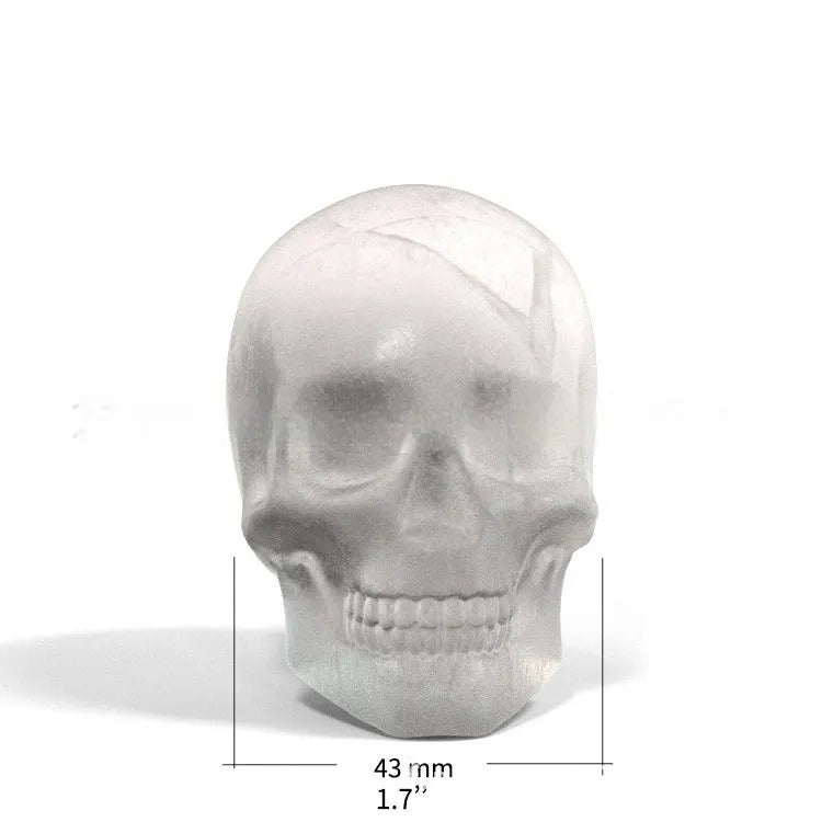 White silicone ice cube tray with detailed 3D skull mould cavities.
