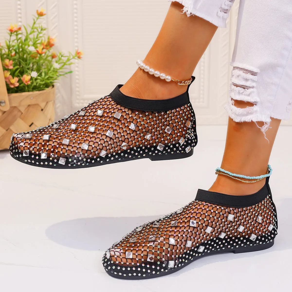 Colourful rhinestone detail on women's white mesh flat sandals with a round toe and rubber sole.