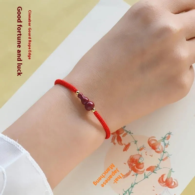 Traditional Chinese cinnabar bracelet with heart-shaped centrepiece and peace buckle clasp on coloured rope cord