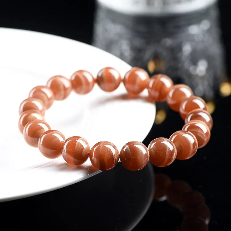 Natural old mine rhodochrosite round bead bracelet with ruyi detail, shown in 6mm and 8mm size options.