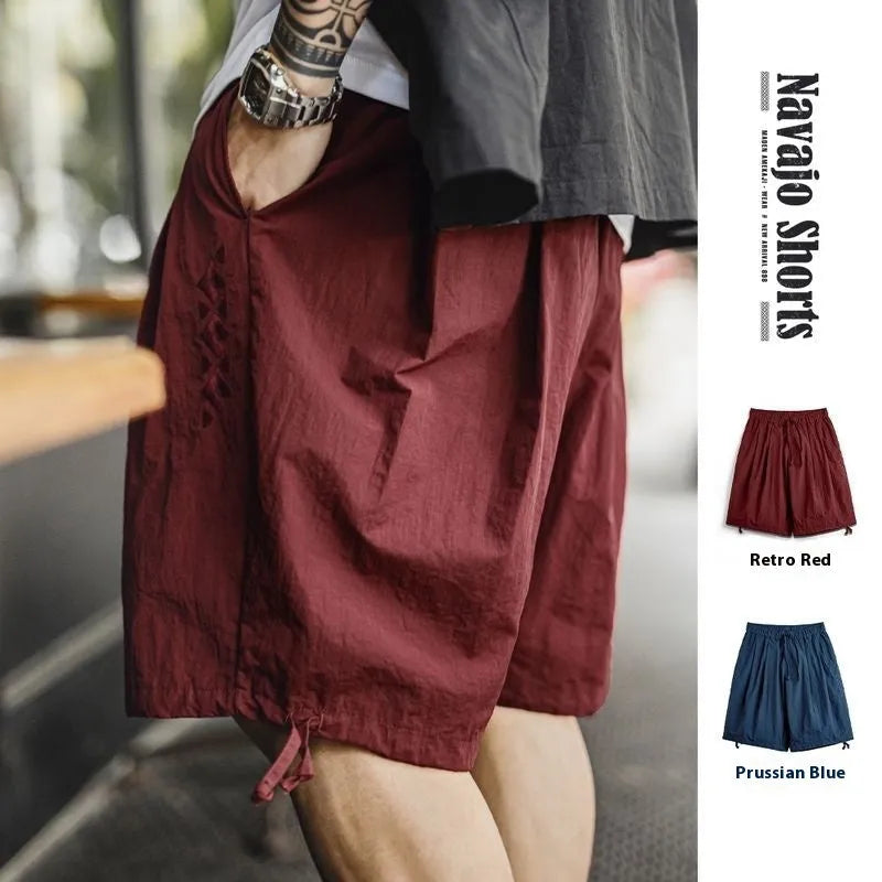 Prussian blue men's nylon loose beach shorts with embroidery on knee-length leg.