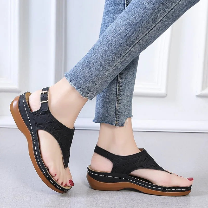 Women's red wedge heel flip flop sandals with an adjustable buckle strap on a white background.