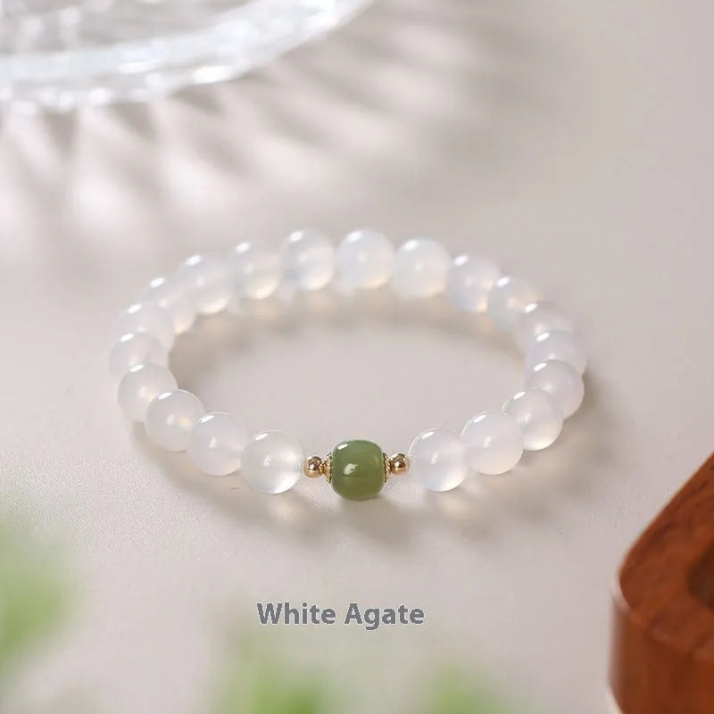 Handmade white agate and crystal bracelet with cinnabar inlay and text charm.