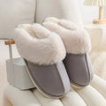 Women's plush winter slippers in grey with a round toe, flat heel, and non-slip PVC sole.