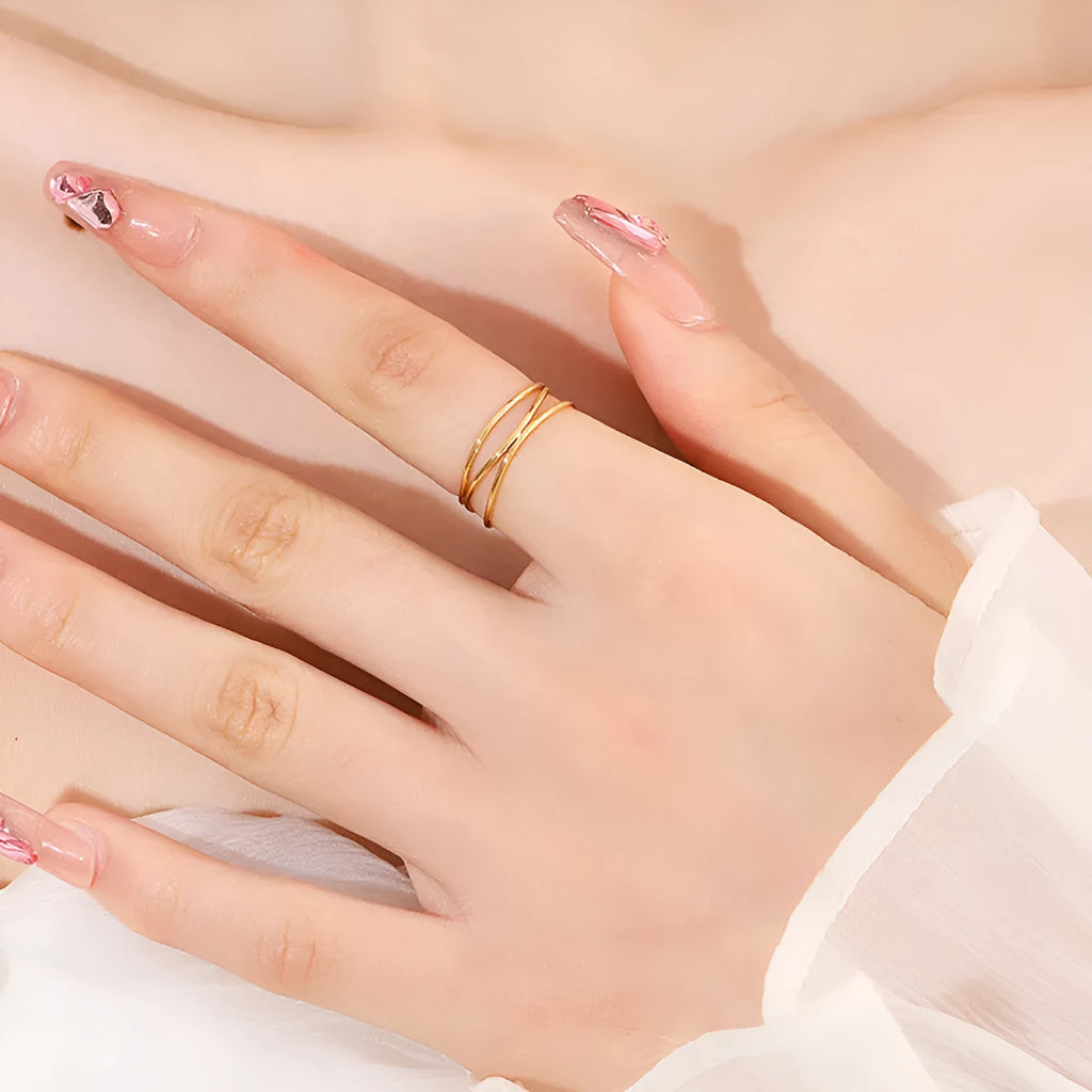 Gold geometric titanium steel coil ring showing three-layer bracelet-like design on a finger.