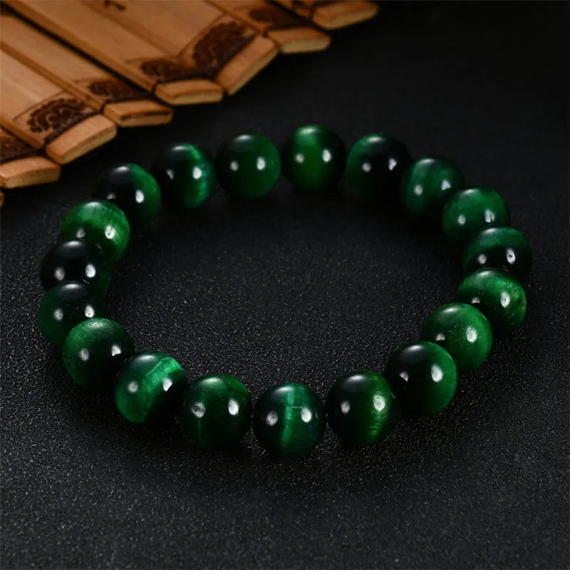 A natural green tiger eye stone bracelet with polished geometric beads on a wrist.