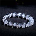 Women's adjustable white crystal ghost pyramid bracelet with Ruyi charm on wrist.