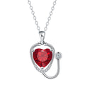 Red diamond stethoscope necklace with a wing and cross pendant on a chain.