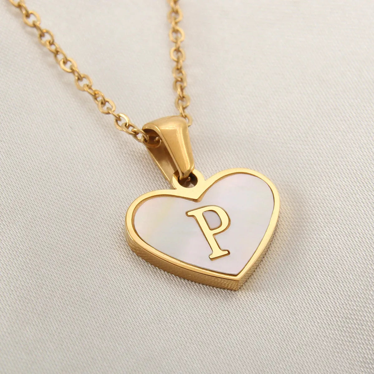 Gold plated chain necklace with a white shell heart-shaped pendant personalised with a single letter initial.