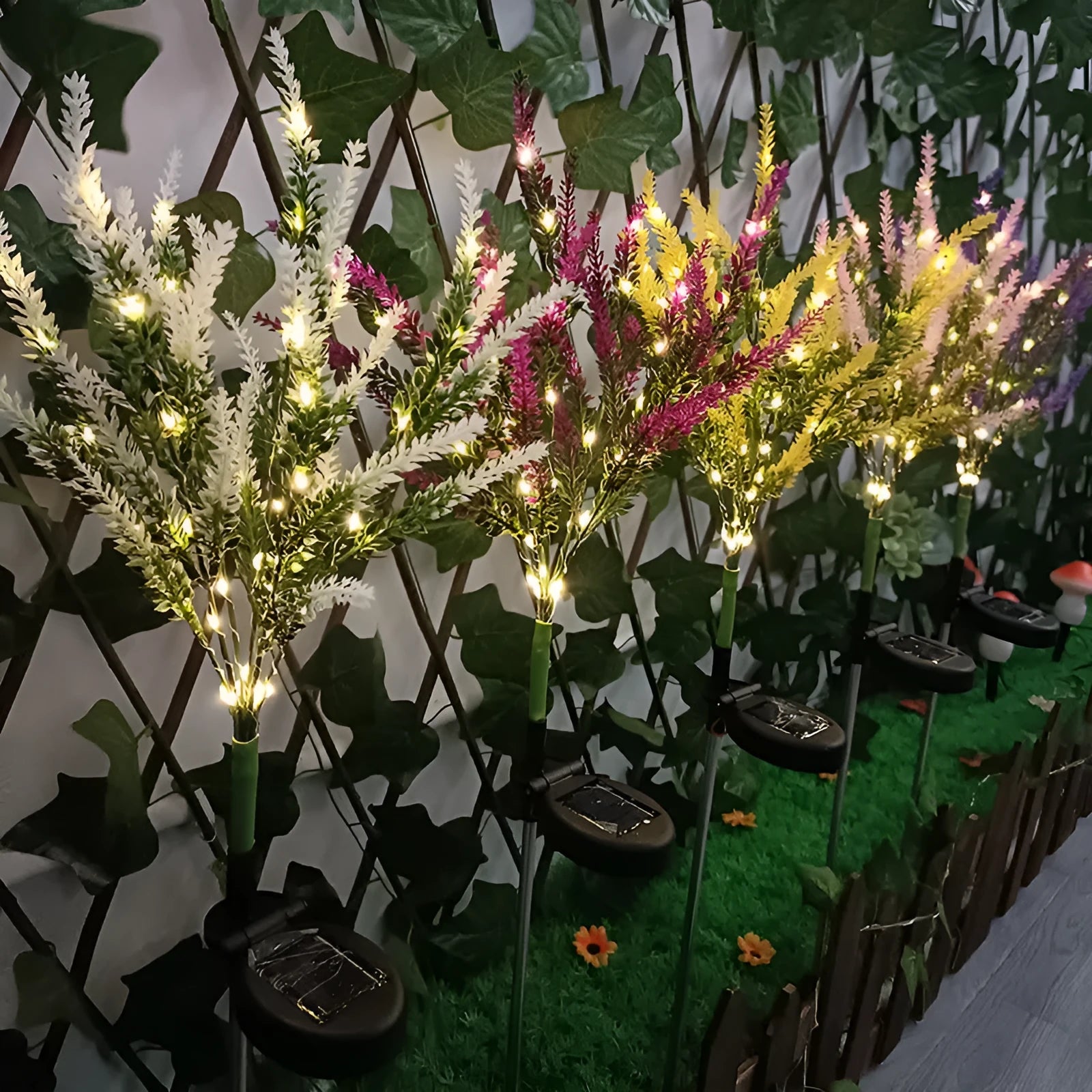 74cm tall solar-powered lavender-shaped LED garden light with stainless steel stem in a flower bed.