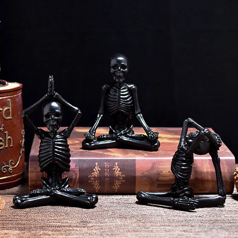 A detailed resin desktop ornament of a yoga-pose skeleton skull in black and white colour options.