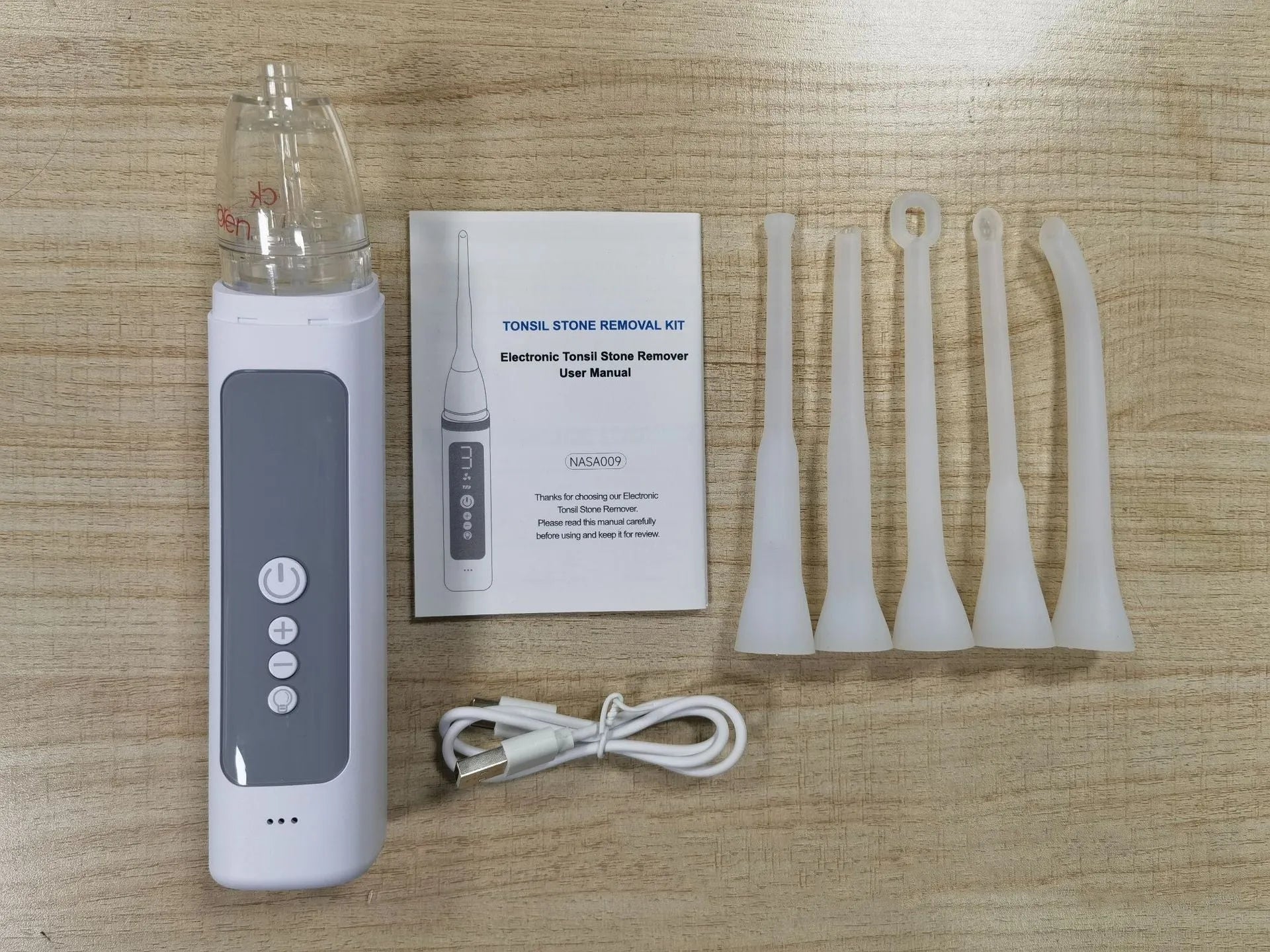 Milky white tonsil stone removal tool oral cleaning kit on a plain background.