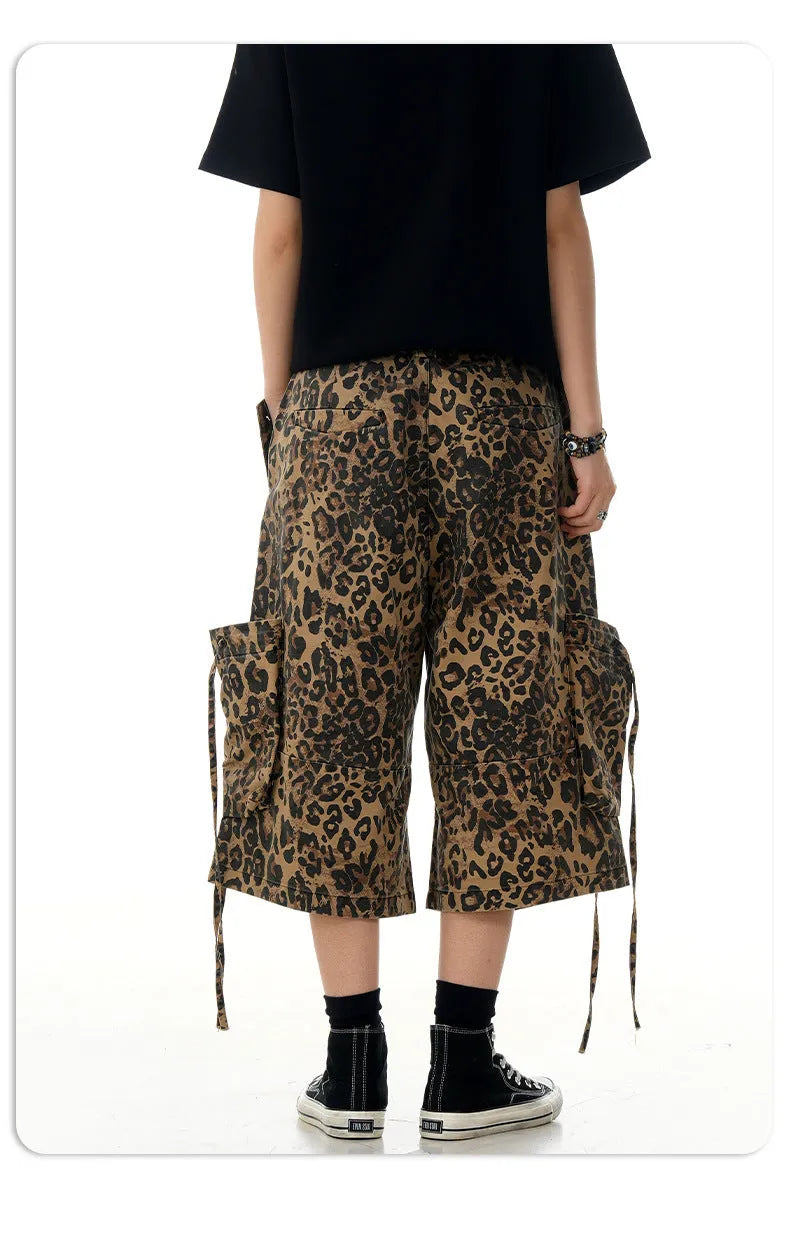 A pair of loose-fitting, high-waisted, straight-leg cropped pants in a leopard print pattern.