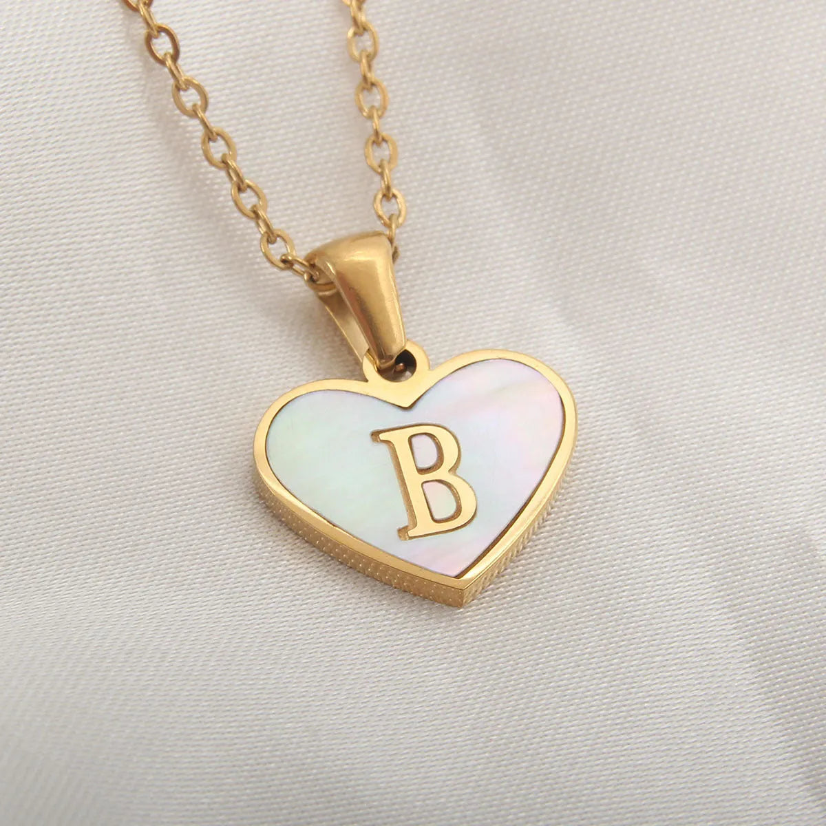 Gold plated chain necklace with a white shell heart-shaped pendant personalised with a single letter initial.
