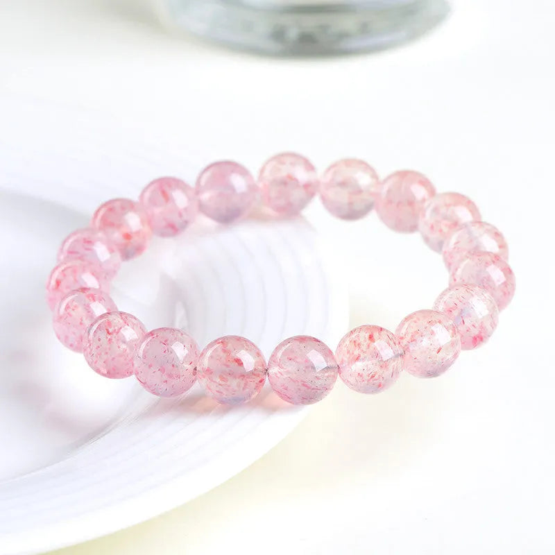 Natural white water strawberry quartz bracelet with 10-10.8mm geometric beads on a wrist.