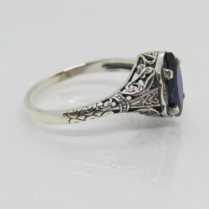 Silver geometric hollow alloy women's ring on a grey background