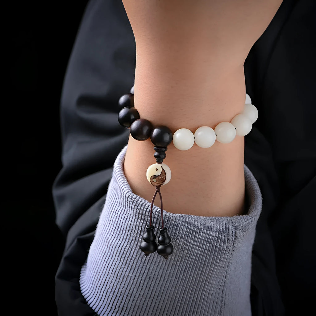 Close-up of a white retro eight-diagram-shaped Bodhi bead bracelet with 11mm beads on a black background.