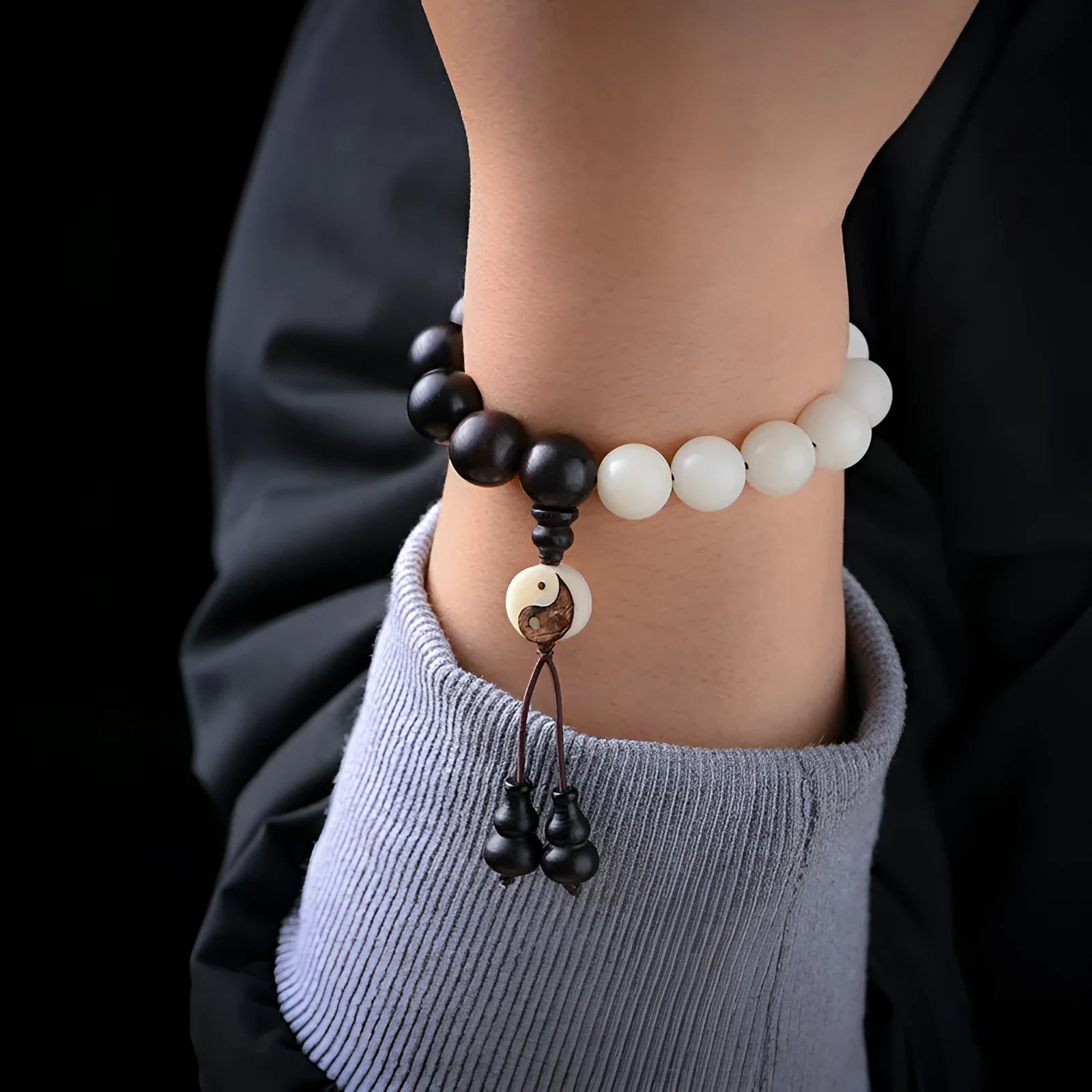 Close-up of a white retro eight-diagram-shaped Bodhi bead bracelet with 11mm beads on a black background.