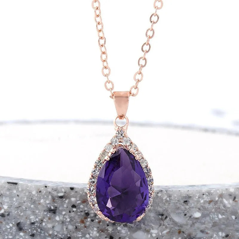 Water drop shaped geometric pendant necklace with rhinestone detailing in rose gold pink colour
